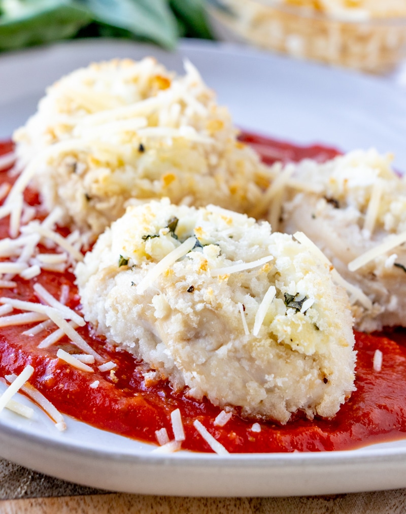 Chicken Parmesan Rollups laying on marinara and sprinkled with parmesan.