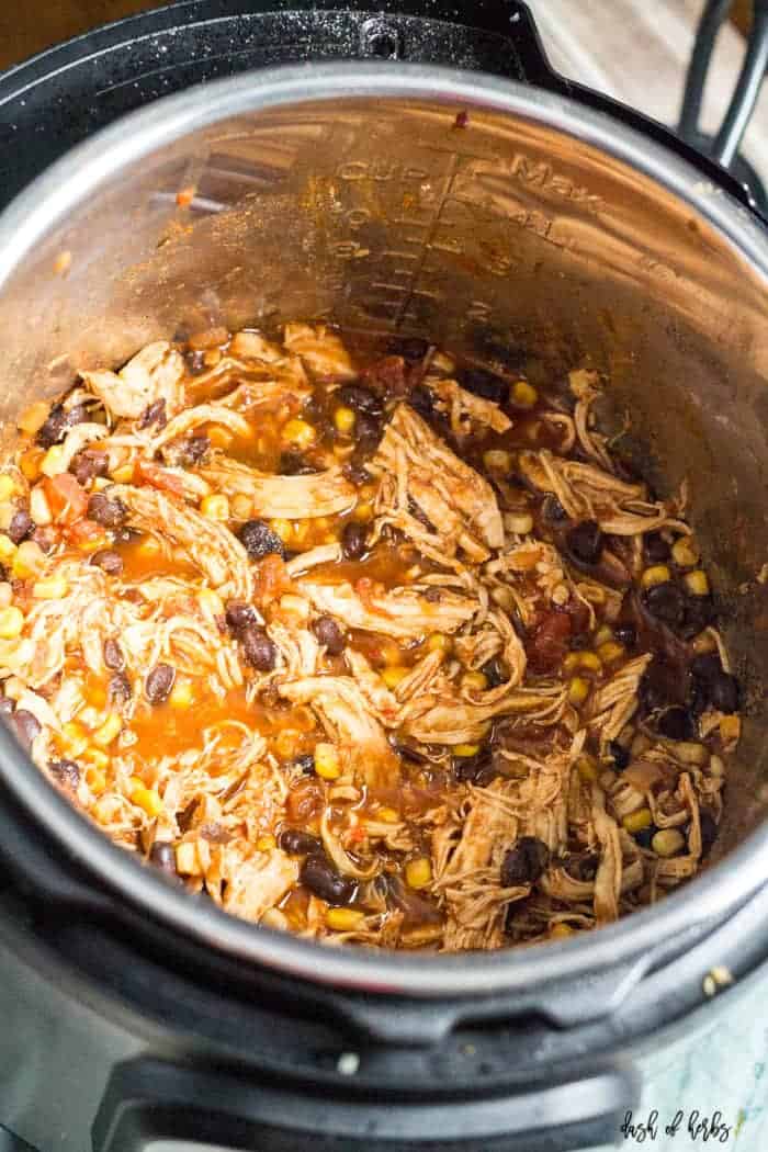 This is a close up image of the Instant Pot Salsa Chicken recipe in the Instant Pot. You can see the shredded chicken, black beans, and corn clearly in this picture.